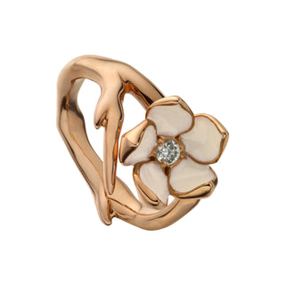 Rose gold ring with a floral design and diamond on a light gray background